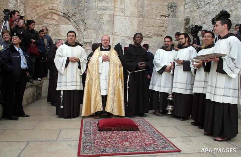 Clergymen stand outside the Church of the Nativity, believed by many to be the birthplace of Jesus Christ, in the West Bank town of Bethlehem, on 24 December 2009. Photo by Najeh Hashlamoun