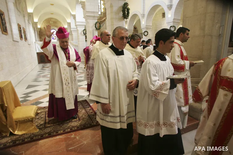 Latin Patriarch of Jerusalem Fouad Twal, center,waves in the Church of Nativity, traditionally believed by Christians to be the birthplace of Jesus Christ, in the West Bank town of Bethlehem, Thursday, Dec. 24, 2009. The...