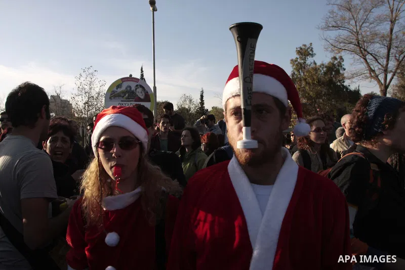 A left-wing activist wearing a Snata Claus outfit blows a horn(reading 'Free Palestine') during a protest on Christmas Day, 25 December 2009 at a disputed house taken over by Jewish settlers in the Sheihk Jarrah neighbor...