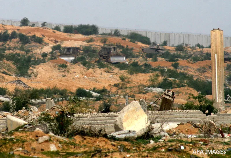 An Israeli army Merkava tanks are seen driving through an area heavily bombed during last year's war near Erez crossing in northern Gaza Strip December 26, 2009. Earlier today in the same area, soldiers shot and killed t...