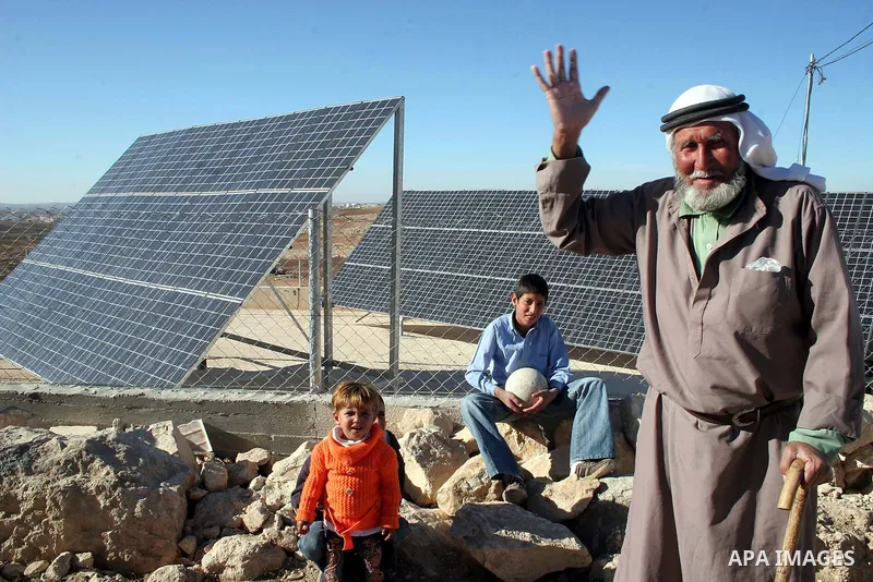 An elderly Palestinian man walks next to the solar cells in the West Bank village of Mneizel southern the West Bank city of Hebron, 27 December 2009. Photo by Najeh Hashlamoun..