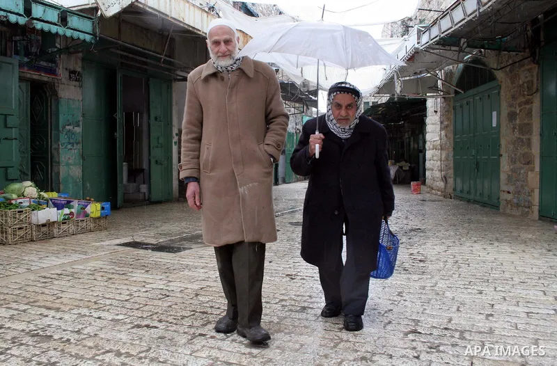 Palestinian men walk in the market in the old city of West Bank city of Hebron January 25, 2010. Photo by Najeh Hashlamoun