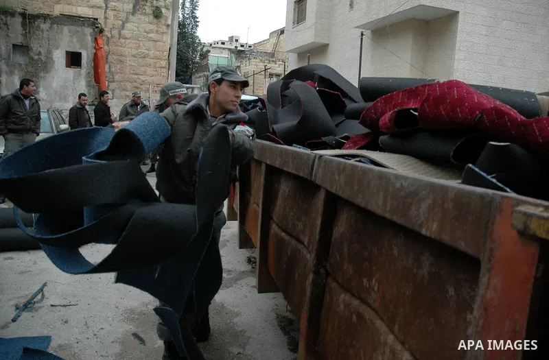 Palestinian policemen destroy an Israeli products in the West Bank city of Nablus on Jan 26,2010. Photo by Nedal Shtieh