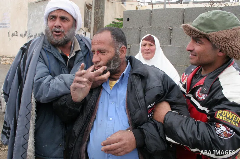 Palestinian men carry a man after a confrontation between settlers with Palestinians in Twanie near the West Bank village of Yatta southern the West Bank city of Hebron January 26,2010. Photo by Najeh Hashlamoun