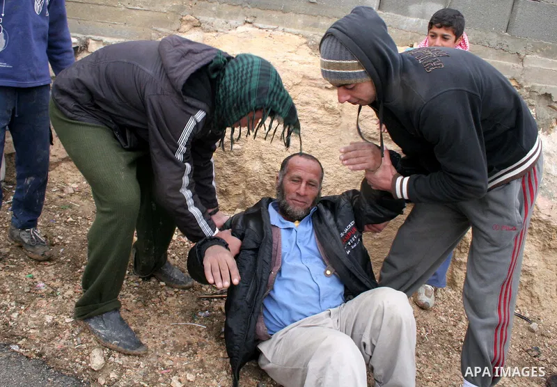 Palestinian men carry a man after a confrontation between settlers with Palestinians in Twanie near the West Bank village of Yatta southern the West Bank city of Hebron January 26,2010. Photo by Najeh Hashlamoun