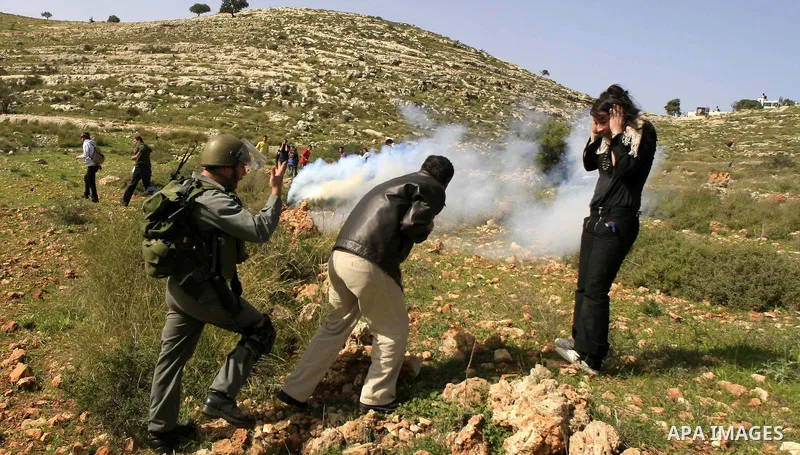 An Israeli soldier fire tear gas canister during a protest by Palestinians over water supplies in the West Bank village of Nabi Salah, Friday, Feb. 19, 2010. The water supply is used by Jewish settlers from the nearby se...