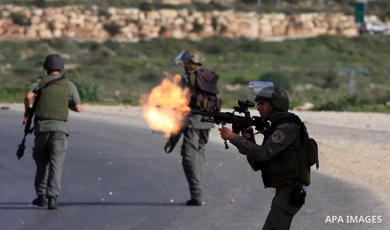 An Israeli soldier shoots fire at Palestinian protesters during a protest by Palestinians over water supplies in the West Bank village of Nabi Salah, Friday, Feb. 19, 2010. The water supply is used by Jewish settlers fro...