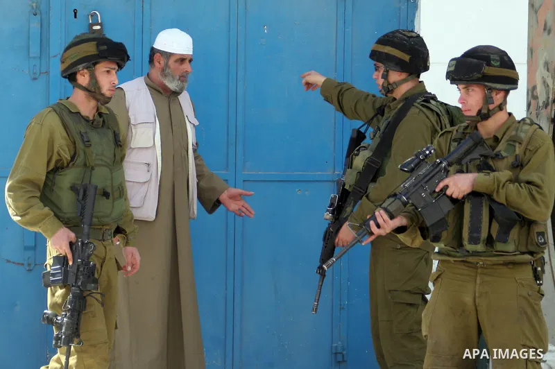 Israeli soldiers tell a Palestinian vendor to close down his shop after scuffles in the West Bank city of Hebron, Tuesday, Feb. 23, 2010. Scuffles continued in Hebron Tuesday, after Palestinian youths pelted Israeli sold...