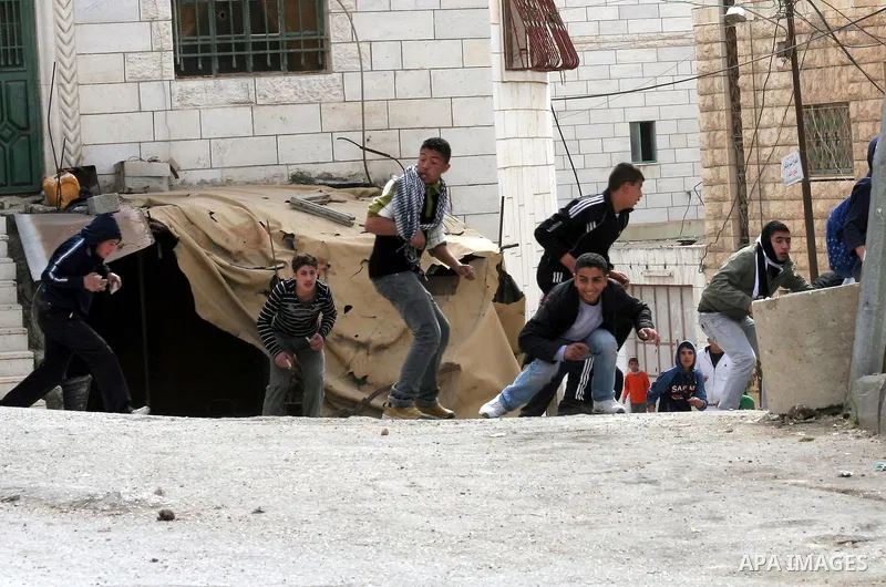 Palestinians throw stones at Israeli soldiers in the West Bank city of Hebron February 24, 2010, after Israel's Prime Minister Benjamin Netanyahu was quoted in a statement as saying that the Tomb of the Patriarchs, a sit...