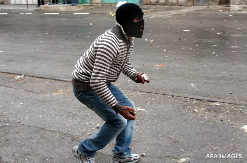 Palestinian yputh throws stones at Israeli soldiers in the West Bank city of Hebron February 25, 2010, after Israel's Prime Minister Benjamin Netanyahu was quoted in a statement as saying that the Tomb of the Patriarchs,...
