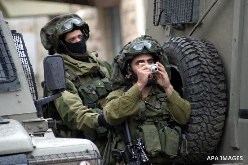 Israeli soldiers take position during the Jewish settlers take part in a parade for the holiday of Purim in the West Bank city of Hebron February 28, 2010. Purim is a celebration of the Jews' salvation from genocide in a...