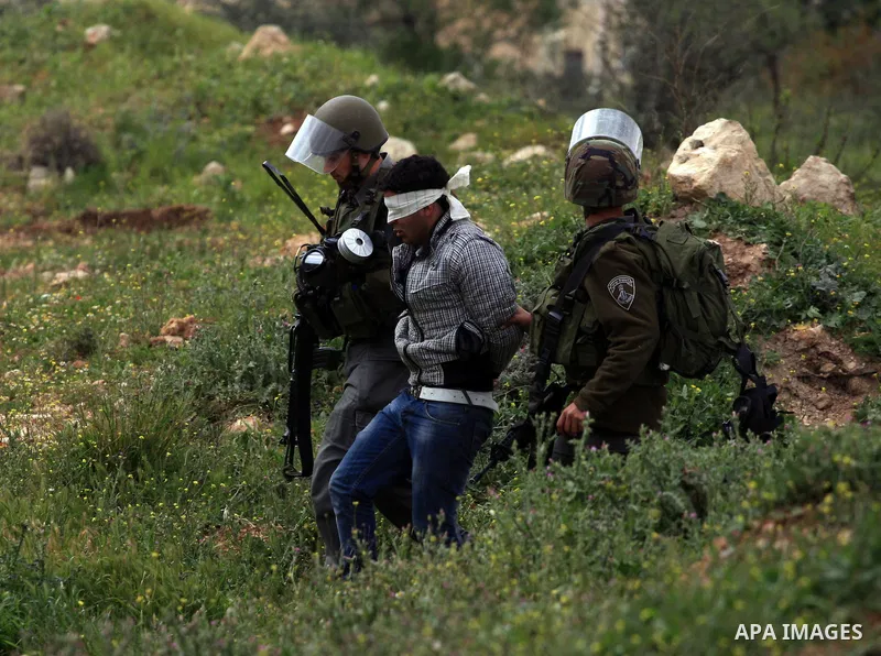 An Israeli border police officer fires a tear gas canister towards Palestinian stone-throwers during scuffles in the West Bank village of Bilin near Ramallah, March 5, 2010. Photo by Issam Rimawi