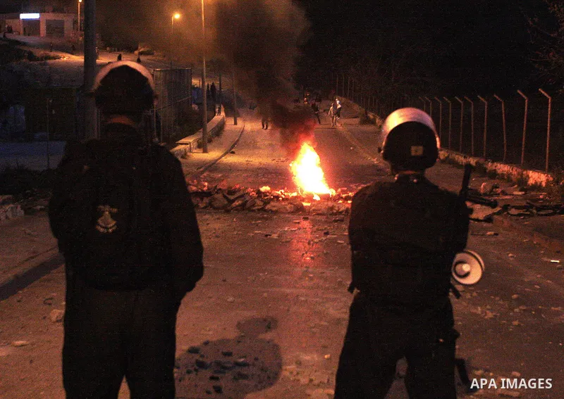 Palestinian youths (back) throw stones at Israeli soldiers (front) during clashes at East Jeruslaem neighbourhood of Issawiya on March 6, 2010. Photo by Mohamar Awad