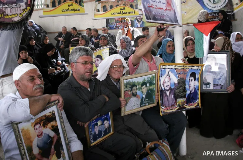 Palestinian women and men hold pictures of jailed relatives during a protest calling for the release of Palestinian prisoners from Israeli jails at the Red Cross office in Gaza City on March 15,2010. Photo by Yousef Deeb