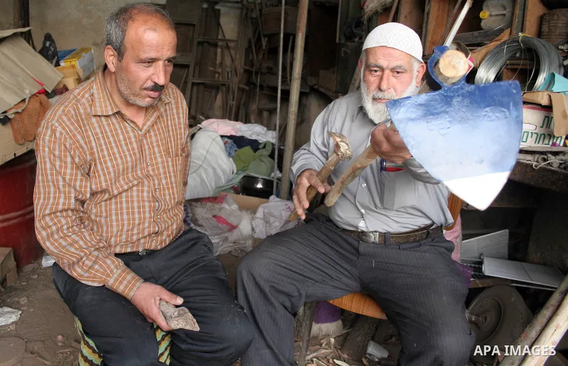 A Palestinian man Abed Al Mneem Al Natshah 65 years old is working in his work shop of handicrafts wood in making the wooden sticks in the West Bank city of Hebron on March 15, 2010. Palestinians use the wood of oak tree...