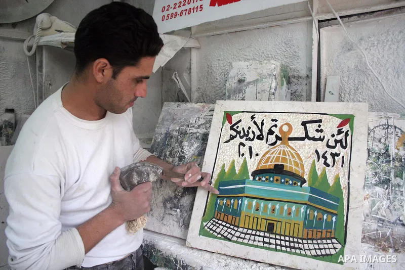 Palestinian worker carves a representation of the Dome of the Rock on a marble stone for housing building in the West Bank city of Hebron on March 16, 2010. Photo by Najeh Hashlamoun