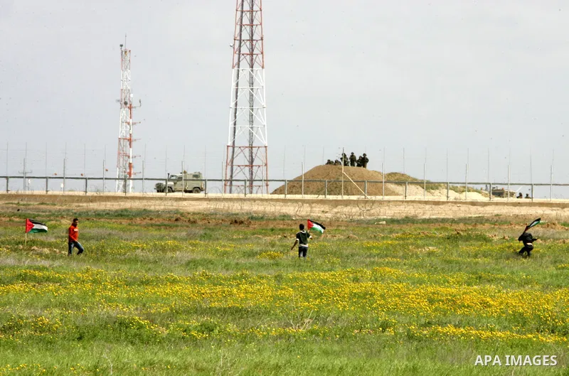 A Palestinian youths wave with national flag during a protest against an Israeli decision to tighten the border area in Khan Yunis, south of the blockaded Gaza Strip, on March 18, 2010. An Al-Qaeda-inspired militant grou...