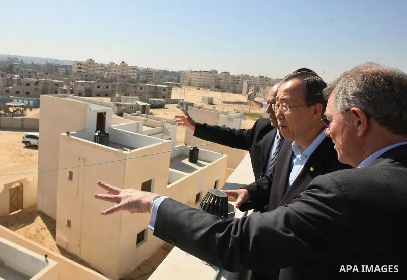 U.N. Secretary-General Ban Ki-moon looks at new houses, built with U.N. funding for Palestinians who lost their homes during Israel's three-week offensive last year, in Khan Younis in the southern Gaza Strip March 21, 20...