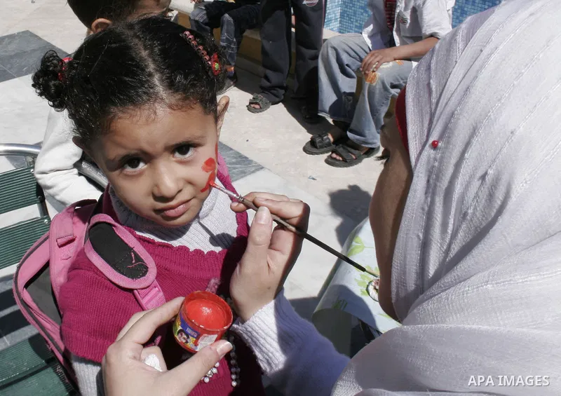 Palestinian girl paints her face with drawings to mark the anniversary of Mother's Day in Gaza city on March 21,2010. Photo by Yousef Deeb