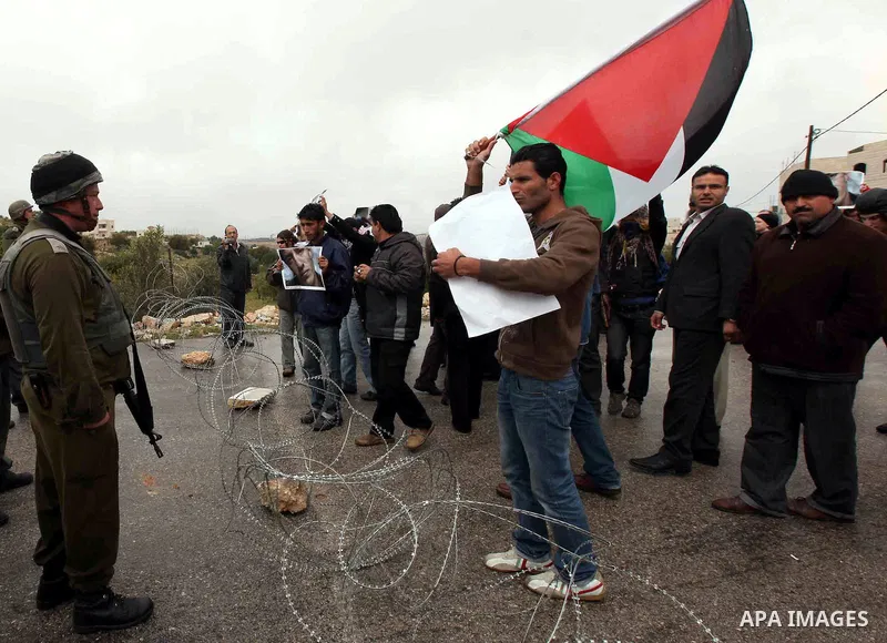Israeli soldiers stand guard as Palestinian Chief Islamic Justice of Tayssir al-Tamimi and Palestinian Muslim stand next to demonstrators during a protest against Israel's separation barrier in the West Bank village of M...