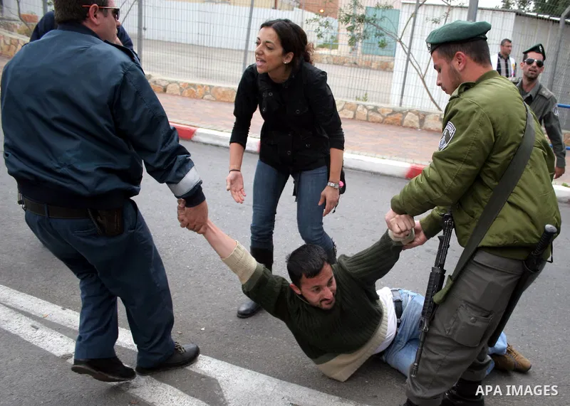 Israeli border police officers detain a Palestinian activist at a checkpoint in the West Bank town of Bethlehem March 28, 2010. Israeli border police clashed on Sunday with dozens of Palestinian Christians and Israeli ac...
