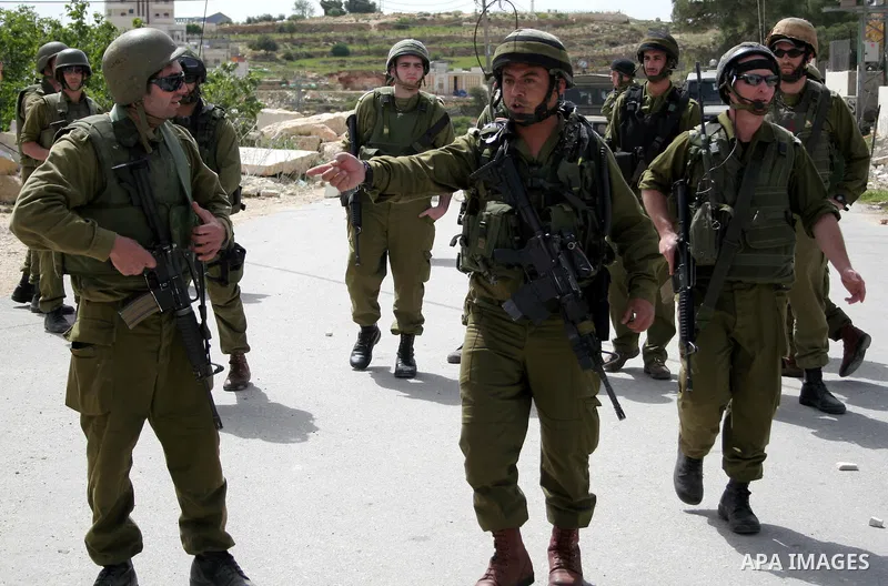 Israeli soldiers and Israeli border policemen stand guards as Palestinian , Israeli activists and International activists during a rally against Israel's separation barrier in the West Bank village of al-Masarah near Bet...