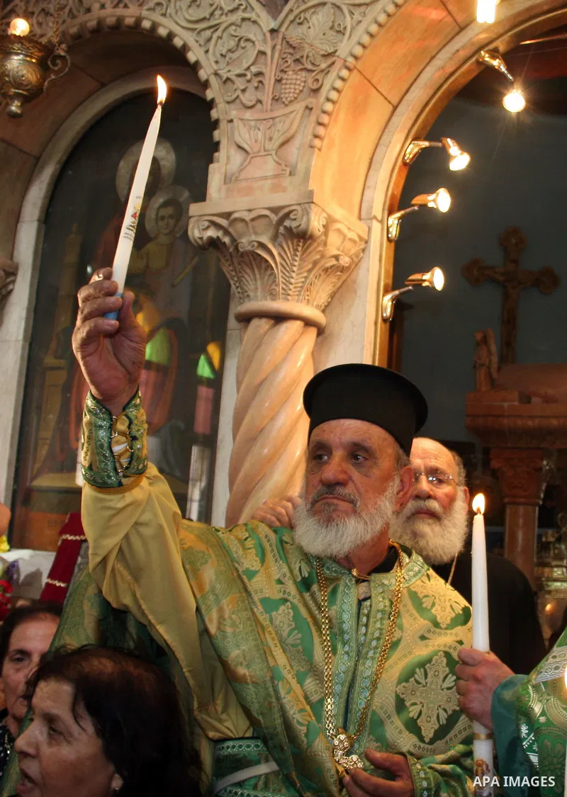 An Orthodox Christian pilgrims hold burning candles in the West Bank town of Beit Sahour near Bethlehem on 03 April 2010. Orthodox Christians believe a holy fire appears spontaneously from Jesus' tomb on the day before t...