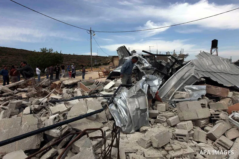 A Palestinian man inspects a house which was demolished by Israeli troops in the West Bank village of Al-Khader near Bethlehem on April 14, 2010. The house was destroyed for being close to Israel's controversial seperati...