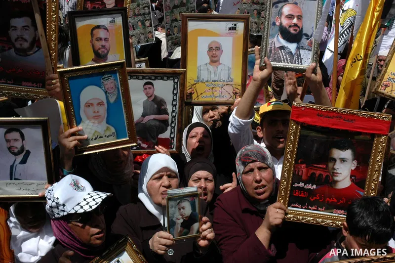 Palestinians hold pictures of their jailed relatives during a protest in the West Bank city of Nablus April 15, 2010, calling for the release of Palestinian prisoners from Israeli jails. Palestinians mark Palestinian Pri...