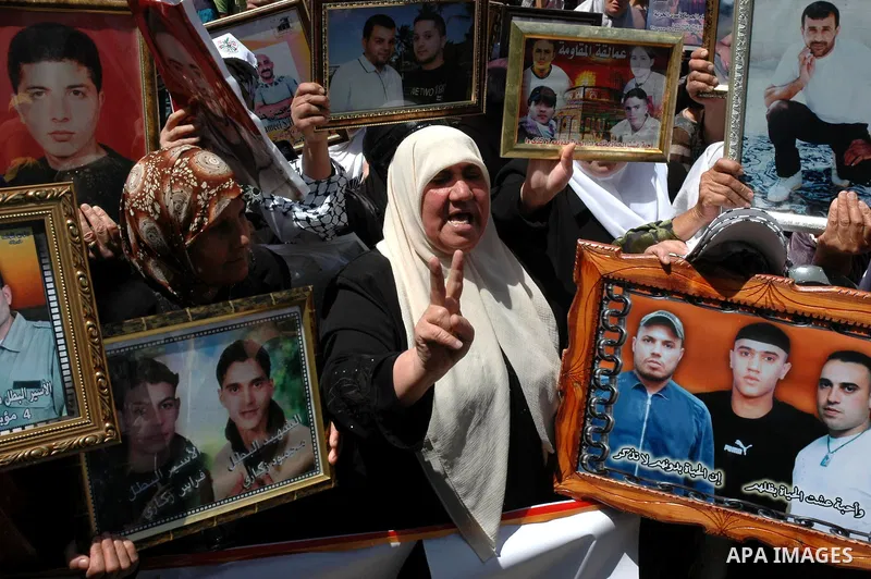 Palestinians hold pictures of their jailed relatives during a protest in the West Bank city of Nablus April 15, 2010, calling for the release of Palestinian prisoners from Israeli jails. Palestinians mark Palestinian Pri...