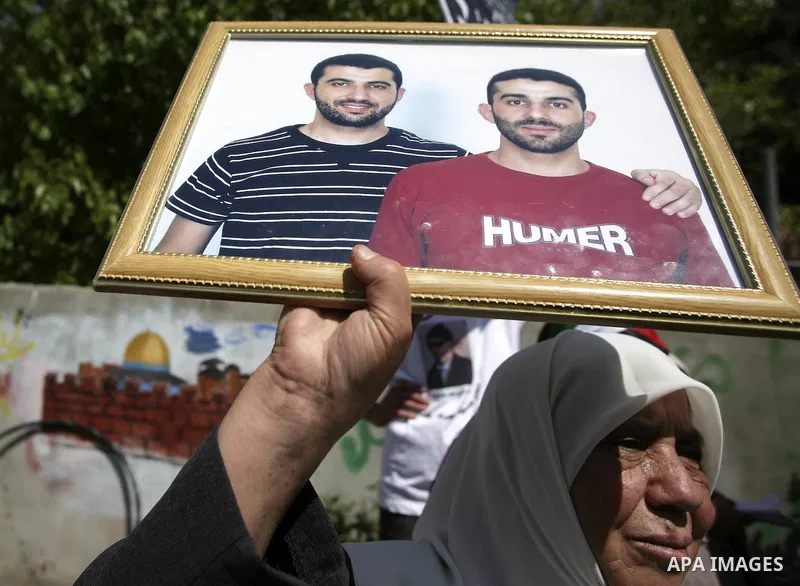 A Palestinian woman holds pictures of her jailed relatives during a protest in the Sheikh Jarrah neighbourhood of East Jerusalem April 15, 2010, calling for the release of Palestinian prisoners from Israeli jails. Palest...