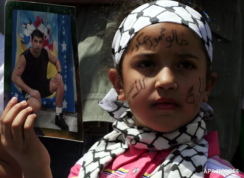Palestinians hold pictures of relatives held in Israeli jails during a protest to mark Prisoner Day in the West Bank city of Ramallah, Saturday, April 17, 2010. Saturday is the annual Prisoners Day which is marked to rem...