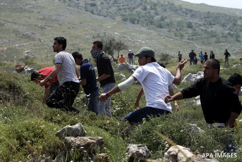 Palestinian youths throw stones at Israeli troops during a protest against the expansion of Israeli settlements in the West Bank village of Iraq Burin near city of Nablus on April 17,2010. Photo by Nedal Shtieh