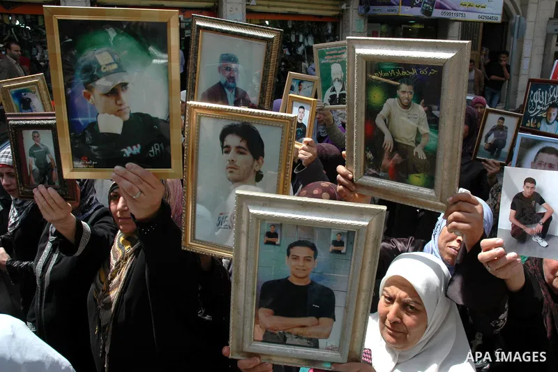 Palestinians hold pictures of their relatives, imprisoned in Israeli jails, during a demonstration calling for their release in the West Bank town of Jenin, Sunday, April 18, 2010. The demonstrators call for the release...