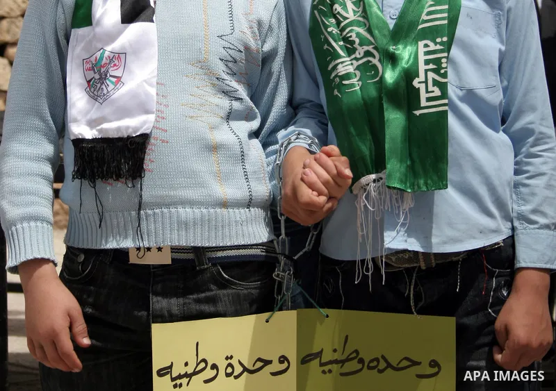 Two Palestinian students of Al-Imam Ali School wear scarves from the Fatah party (L) and the Hamas movement (R) during a demonstration calling for the release of Palestinian prisoners held in Israeli jails, in the West B...