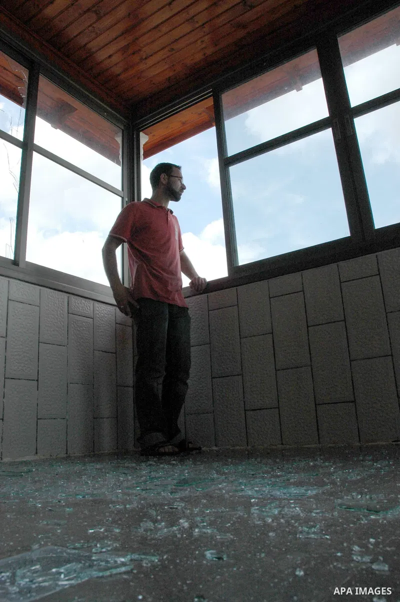A Palestinian youth inspects a broken window, after Jewish settlers marched through the West Bank village of Hawara in a show of anger over what they said was a police campaign against them, Thursday, April 29, 2010. Ult...