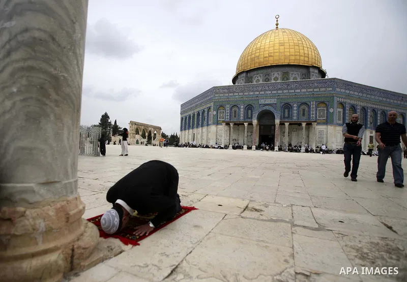 Palestinian Muslim worshippers attend Friday prayers in front of the Dome of Rock in the Al Aqsa Mosque compound, also known to Jews as the Temple Mount, in Jerusalem's old city on April 30, 2010. Photo by Mohamar Awad