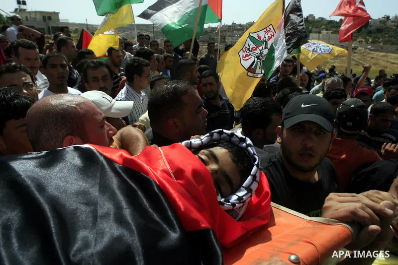 Palestinian mourners carry the body of Ayssar Yasser al-Zaben, 16, during his funeral in the West Bank village of Mazra ash Sharqiya, near Ramallah, on May 14, 2010, An Israeli settler shot dead the 16-year-old Palestini...