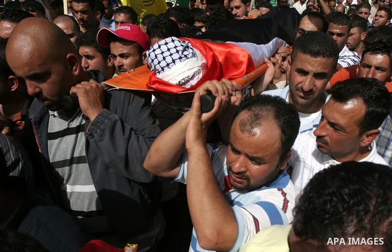 Palestinian mourners carry the body of Ayssar Yasser al-Zaben, 16, during his funeral in the West Bank village of Mazra ash Sharqiya, near Ramallah, on May 14, 2010, An Israeli settler shot dead the 16-year-old Palestini...