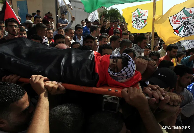Palestinian mourners carry the body of Ayssar Yasser al-Zaben, 16, during his funeral in the West Bank village of Mazra ash Sharqiya, near Ramallah, on May 14, 2010, An Israeli settler shot dead the 16-year-old Palestini...