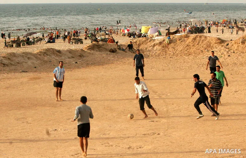 Palestinian youths play football at the beach of Gaza City May 14, 2010. Photo by Ali Jaad Allah.