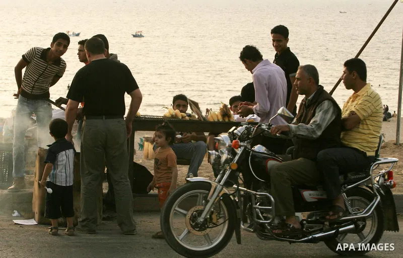 Palestinians eat corn at the beach of Gaza City May 14, 2010. Photo by Ali Jaad Allah.