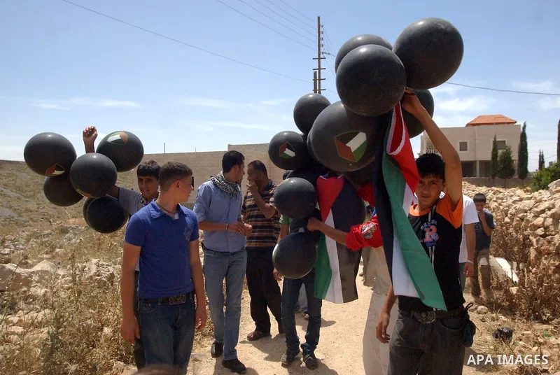 Palestinians holding black balloons during a demonstration against the expansion of Jewish settlements in the West Bank village of Iraq Burin, south of Nablus, on May 15, 2010 as Palestinians marked 62 years since the "N...