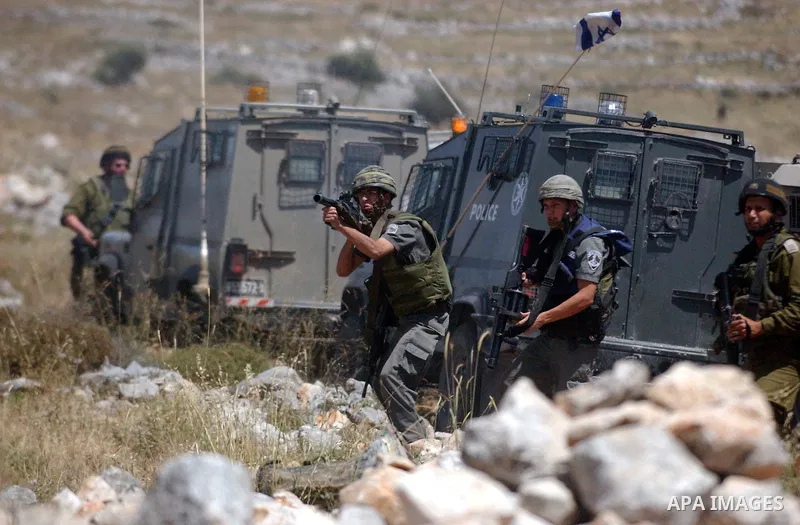 Israeli soldiers fire tear gas canisters towards Palestinian protesters during a demonstration against the expansion of Jewish settlements in the West Bank village of Iraq Burin, south of Nablus, on May 15, 2010 as Pales...