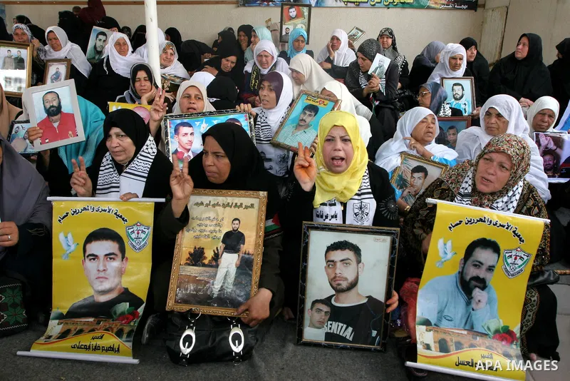 Palestinian women hold pictures of jailed relatives during a protest calling for the release of Palestinian prisoners from Israeli jails at the Red Cross office in Gaza City on May 17,2010. Photo by Ashraf Amra