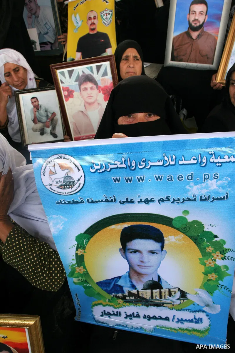 Palestinian women hold pictures of jailed relatives during a protest calling for the release of Palestinian prisoners from Israeli jails at the Red Cross office in Gaza City on May 17,2010. Photo by Ashraf Amra