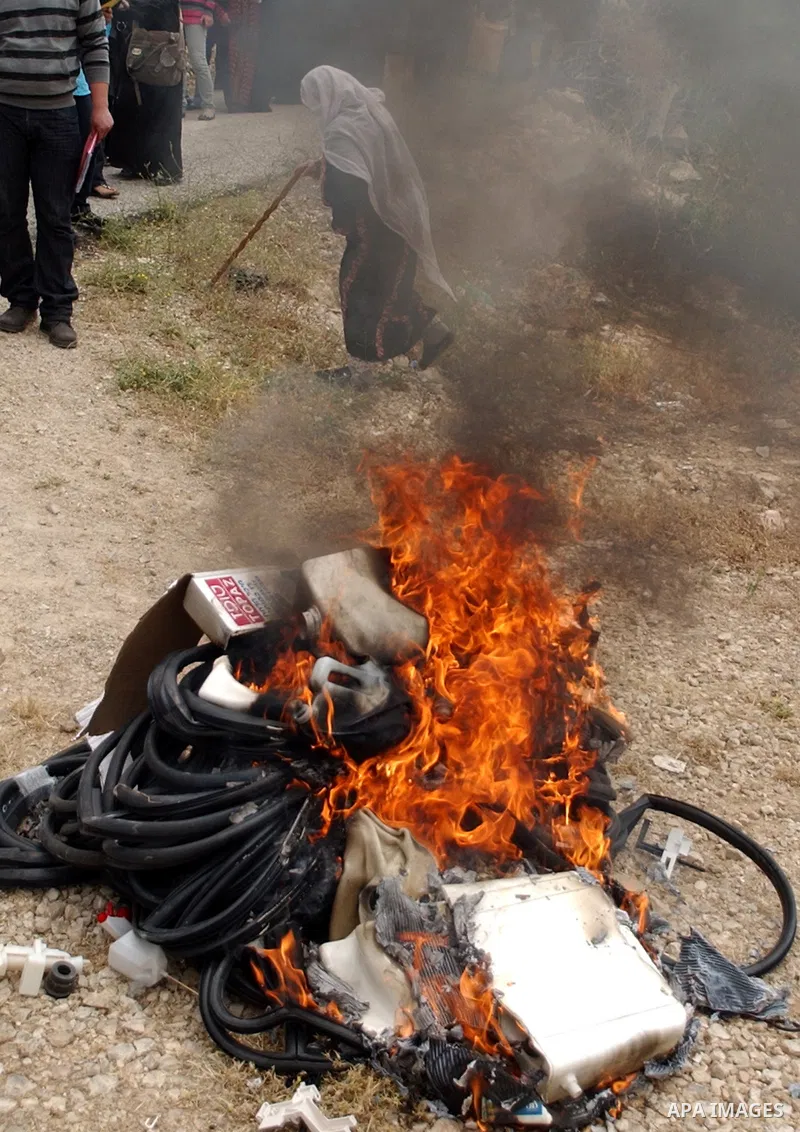 Palestinians burn the Jewish settlements products, in the west Bank city of Salfit on May 18, 2010. Photo by Wagdi Eshtayah