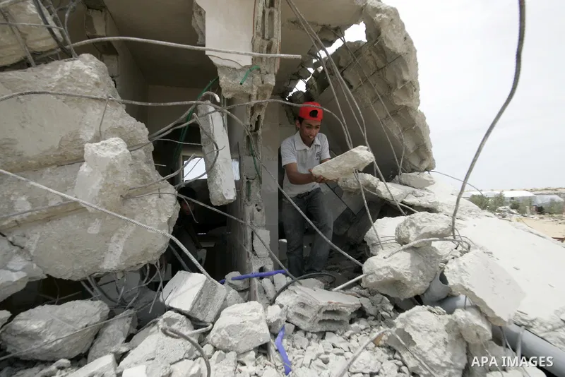 A Palestinian youth inspects his belongings after his house was demolished by Hamas security forces in Rafah in the southern Gaza Strip on May 19, 2010. Hamas Islamists ruling the Gaza Strip have been demolishing Palesti...