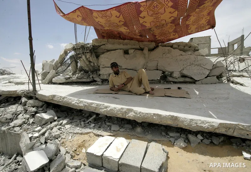 A Palestinian man relaxes on the ruins of the house was demolished by Hamas security forces in Rafah in the southern Gaza Strip on May 19, 2010. Hamas Islamists ruling the Gaza Strip have been demolishing Palestinian hom...
