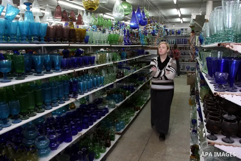 A foreign woman looks at a different types of glasses in AL-Salam factory in the West Bank city of Hebron on May 21, 2010. Glass has been a traditional industry in Hebron for over 600 years but as a result of the increas...